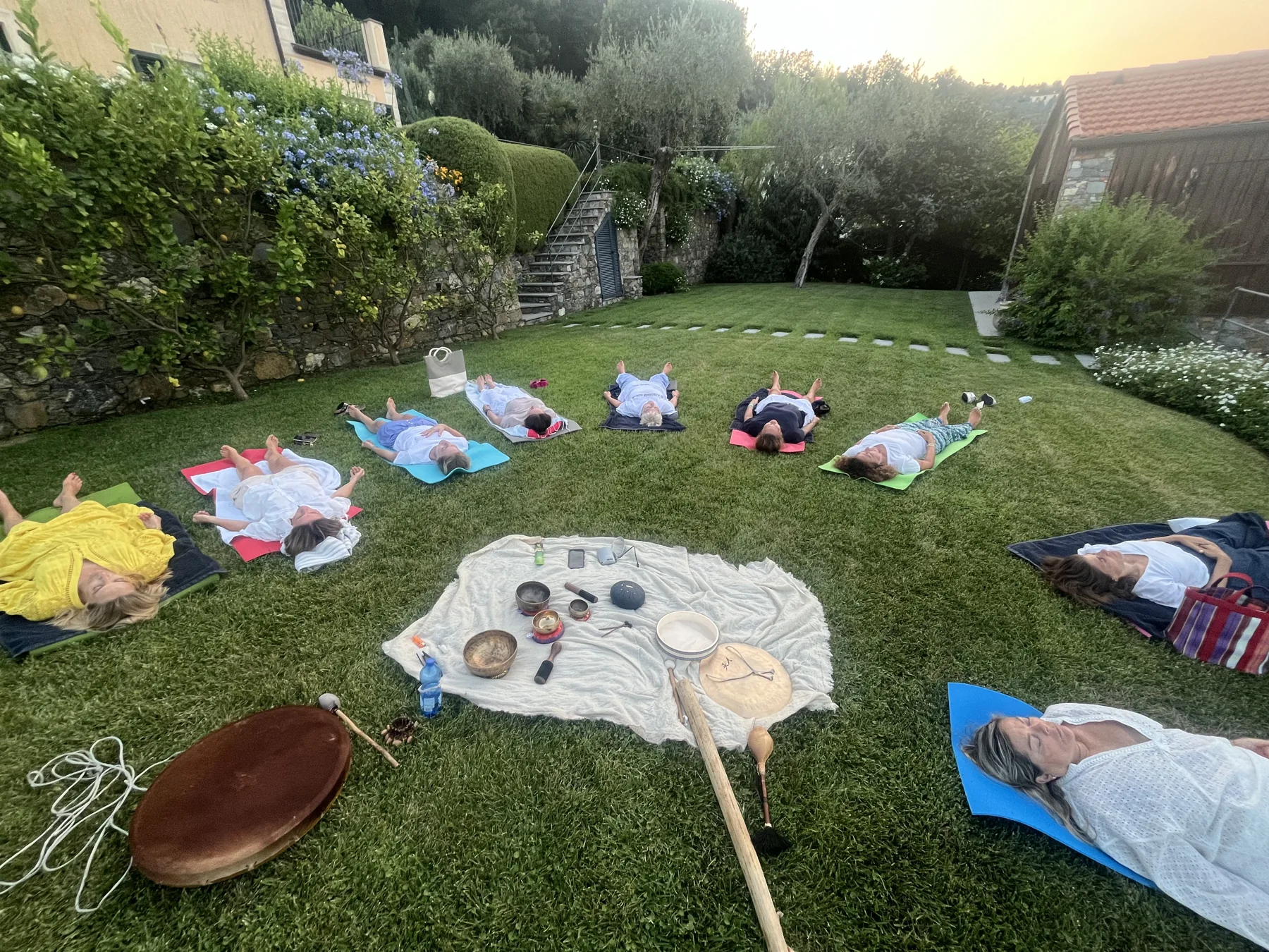Partecipanti distesi sull’erba durante una pratica collettiva