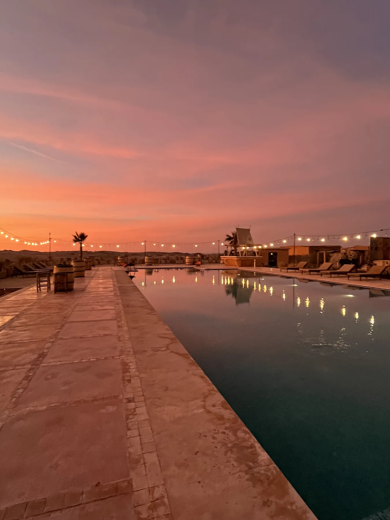 La piscina della struttura del retreat sotto un cielo rosa al tramonto
