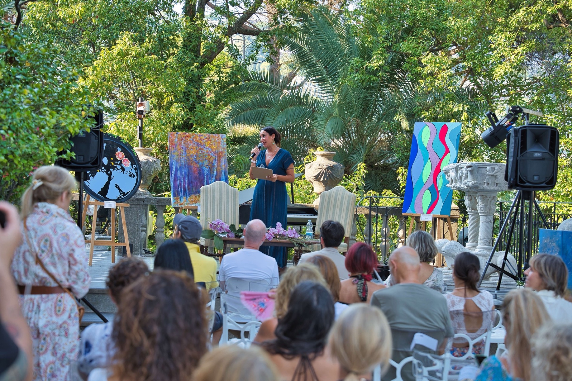 Il pubblico e il palco di Santa Olistica nel parco di Villa Durazzo